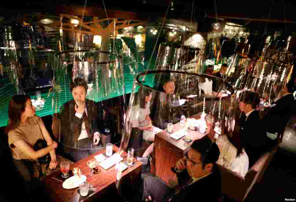 Goldfish bowl-like screens used as part of new social distancing measures and prevention of infection against the COVID-19 are put up at Jazz Lounge Encounter, a night club in the Ginza district in Tokyo, Japan.