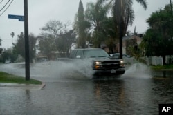 A truck makes it way through flooded streets of Panorama City section of the San Fernando Valley in Los Angeles, Feb. 2, 2019. Flash flood warnings were issued for vast swaths of Southern California and authorities urged motorists not to drive through floodwater.