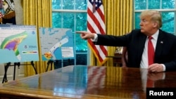 El presidente de Estados Unidos, Donald Trump, habla sobre el huracán Michael junto a mapas y proyecciones acerca de la tormenta durante una reunión con funcionarios del Dpto. de Seguridad Interior y de la agencia federal de manejo de emergencias, FEMA, en la Oficina Oval en la Casa Blanca en Washington, 10 de octubre de 2018. REUTERS / Jonathan Ernst.