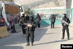 Fighters from a coalition of rebel groups called "Jaish al Fateh" secure territory as fighters and civilians evacuate two besieged Shi'ite towns of al-Foua and Kefraya in the mainly rebel-held northwestern province of Idlib arrive at the border with Turkey in Dec. 2015.