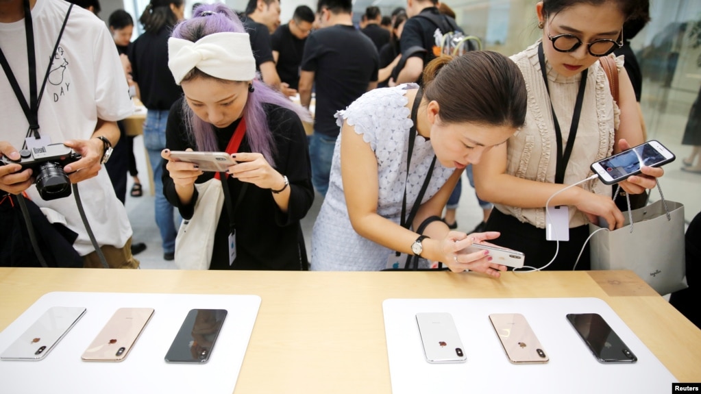 2018年9月21日，上海的苹果公司办公室对媒体展示新产品，人们体验新的Apple iPhone XS和iPhone XS Max。(photo:VOA)