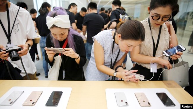 2018年9月21日，上海的苹果公司办公室对媒体展示新产品，人们体验新的Apple iPhone XS和iPhone XS Max。