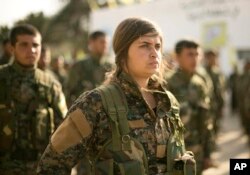 U.S.-backed Syrian Democratic Forces (SDF) stand in formation at a ceremony to mark their defeat of Islamic State militants in Baghouz, at al-Omar Oil Field base, Syria, March 23, 2019.