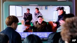 La gente ve un programa de noticias de televisión que muestra una imagen del líder Kim Jong Un, observando una prueba de tierra de un nuevo tipo de motor de cohetes de alto empuje que está llamando un avance revolucionario para el programa espacial del país.