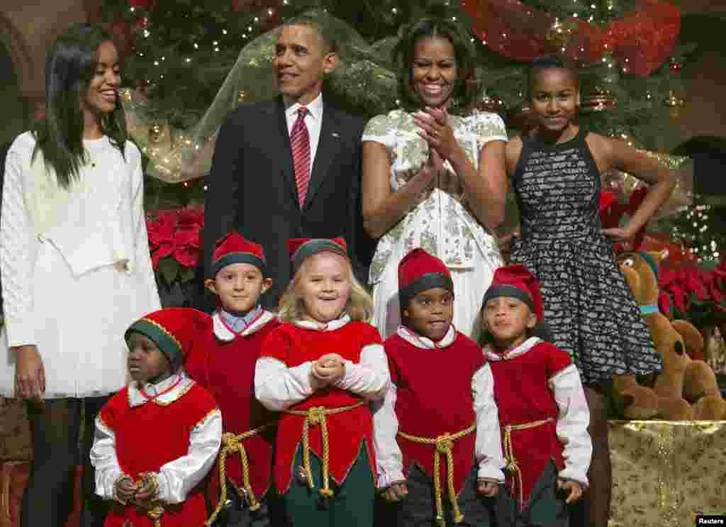 کرسمس کے موقع پر امریکہ کے صدر براک اوباما،خاتون اول مشل اوباما اور ان کی بیٹیاں واشنگٹن میں بچوں کے ایک میڈیکل سینیٹر میں مریض بچوں کے ساتھ کھڑے ہیں۔ 