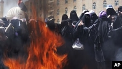 Female Yemeni protesters burn veils during a demonstration demanding the resignation of Yemeni President Ali Abdullah Saleh in Sana'a, Yemen, October 26, 2011.