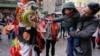 A lion dancer from the Tai Pun Residents Association accepts an offering in a red envelope during a Lunar New Year celebration, in New York's Chinatown neighborhood, Feb. 8, 2016.