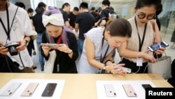 2018年9月21日，上海的苹果公司办公室对媒体展示新产品，人们体验新的Apple iPhone XS和iPhone XS Max。