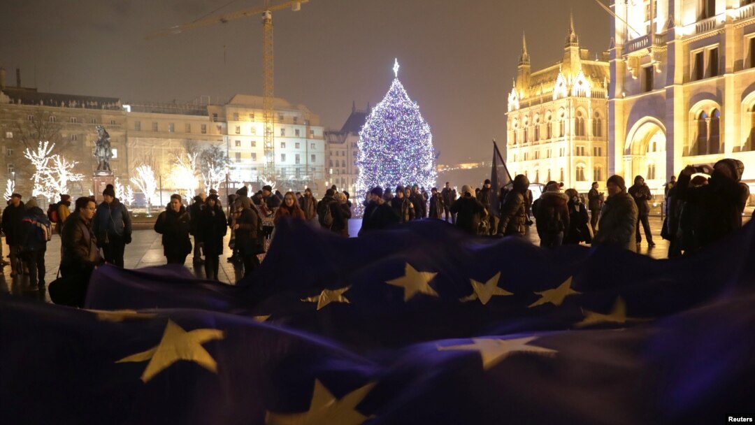 People hold a big European Union flag during a protest against a proposed new labor law, billed as the "slave law," in front of the Parliament building in Budapest, Hungary, Dec. 18, 2018. 