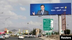 FILE - An image of Lebanese Information Minister George Kordahi is seen on a billboard in Sanaa, Yemen, Oct. 31, 2021. The billboard reads: "Yes, George, Yemen's war is futile."