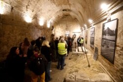 People line up to see an escape tunnel underneath the Berlin Wall that divided the city for 28 years during the Cold War, and was made visible for public for the first time, in Berlin, Germany, Nov. 7, 2019.