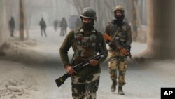 Indian soldiers block a road near the site of a gun battle at Arwani, 55 kilometers (34 miles) south of Srinagar, Indian-controlled Kashmir, Dec. 8, 2016.