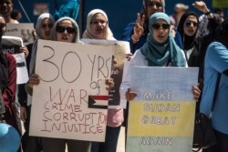 Protesters hold signs at a rally in support of the Sudan's revolution, in Chicago, Illinois, June 29, 2019. (J. Patinkin/VOA)