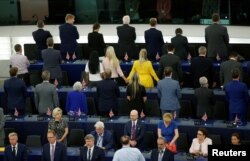 FILE - Members of the Brexit Party turn their back to the assembly as the European anthem is played, during the first plenary session of the newly elected European Parliament in Strasbourg, France, July 2, 2019..
