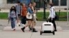 Robot pengantar makanan melintasi jalan di Ann Arbor, Michigan pada Kamis, 7 Oktober 2021. (Foto: AP/Carlos Osorio)