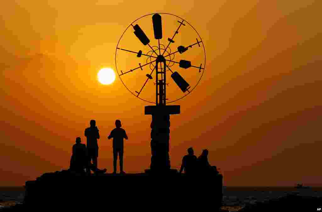 People watch the sunset from the coast of Tripoli city, north of Lebanon.