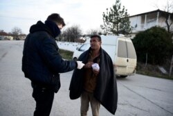 Greek authorities detain a migrant after he entered Greece from Turkey, in the village of Thourio, Evros region near the Greek-Turkish border, March 9, 2020.
