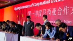 Indonesian President Prabowo Subianto, center left, gestures as he witnesses a signing ceremony of cooperation documents between Indonesia and China during the Indonesia-China Business Forum in Beijing, Nov. 10, 2024. 