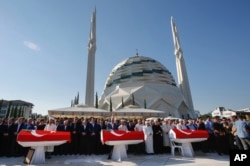 Mourners including Turkish President Recep Tayyip Erdogan attend the funeral of Erdogan's campaign manager Erol Olcak, killed Friday along with his 16-year old son Abdullah and Mustafa Cambaz, while protesting the attempted coup against Turkey's governmen