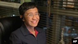 FILE - In this photo provided by the Rappler, Rappler CEO and Executive Editor Maria Ressa reacts after hearing she won the Nobel Peace Prize, inside her home in Taguig, Metro Manila, Philippines, Oct. 8, 2021.