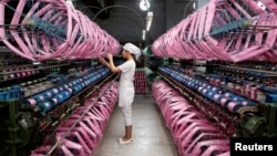 Employee works inside silk factory in Neijiang, Sichuan province, July 3, 2013. 