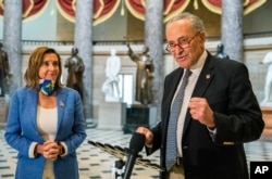 FILE - Senate Minority Leader Chuck Schumer of New York, with House Speaker Nancy Pelosi of California, speaks to reporters following a meeting at the Capitol on a COVID-19 relief bill, Aug. 1, 2020, in Washington.