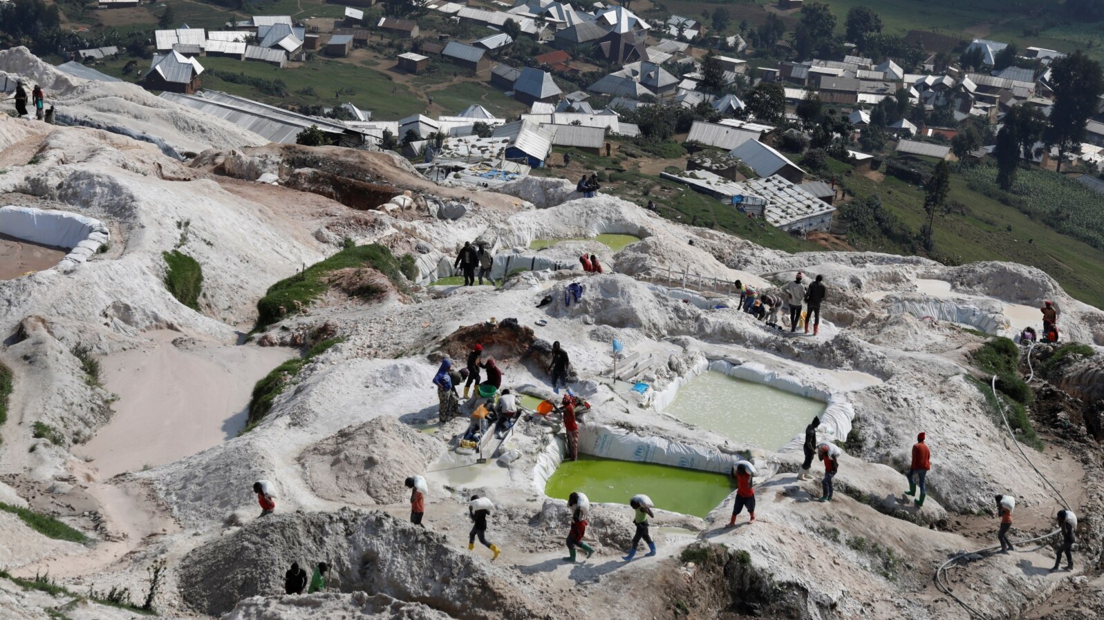 FILE - Laborers carry sacks of ore at the SMB coltan mine near the town of Rubaya in the Democratic Republic of Congo, Aug. 13, 2019.