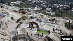 FILE - Laborers carry sacks of ore at the SMB coltan mine near the town of Rubaya in the Democratic Republic of Congo, Aug. 13, 2019.