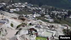 FILE - Laborers carry sacks of ore at the SMB coltan mine near the town of Rubaya in the Eastern Democratic Republic of Congo, Aug. 13, 2019.