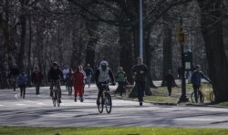 People gather in Brooklyn's Prospect Park as state and city officials urge residents to maintain social distancing to control the growing COVID-19 outbreak, Sunday March 22, 2020, in New York.