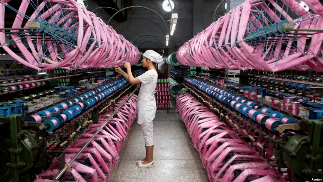 Employee works inside silk factory in Neijiang, Sichuan province, July 3, 2013. 
