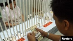 A customer counts Philippine pesos at a money changer in Manila, (File photo).