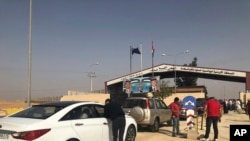FILE - Jordanian cars prepare to cross into Syria, at the Jordanian-Syrian border Jaber crossing point, in Mafraq, Jordan, Oct. 15, 2018.