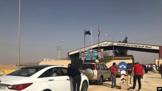 FILE - Jordanian cars prepare to cross into Syria, at the Jordanian-Syrian border Jaber crossing point, in Mafraq, Jordan, Oct. 15, 2018.