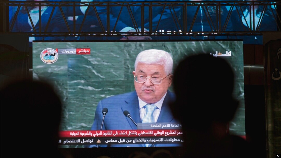 FILE - Palestinians follow President Mahmoud Abbas' speech at the annual U.N. General Assembly, on a large screen in the West Bank city of Ramallah, Sept. 27, 2018. 