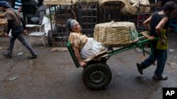 Vendor Carmen Diaz, 84, is pulled by a market porter as she makes her way home at the end of her work day in the Oriental Market in Managua, Nicaragua, April 30, 2015.