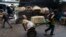 FILE - Vendor Carmen Diaz, 84, is pulled by a market porter as she makes her way home at the end of her work day in the Oriental Market in Managua, Nicaragua, April 30, 2015.