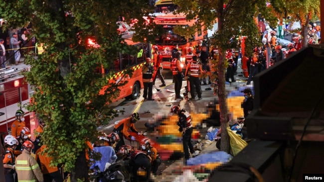 Rescatistase y bomberos trabajan en la escena donde decenas de personas resultaron heridas en una estampida durante una celebración de Halloween en Seúl. Yonhap via REUTERS