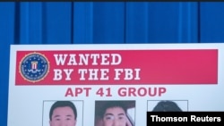 Boletín con fotografía de sospechosos acusados por el Departamento de Justicia de EE.UU. de una campaña global de intrusión informática.