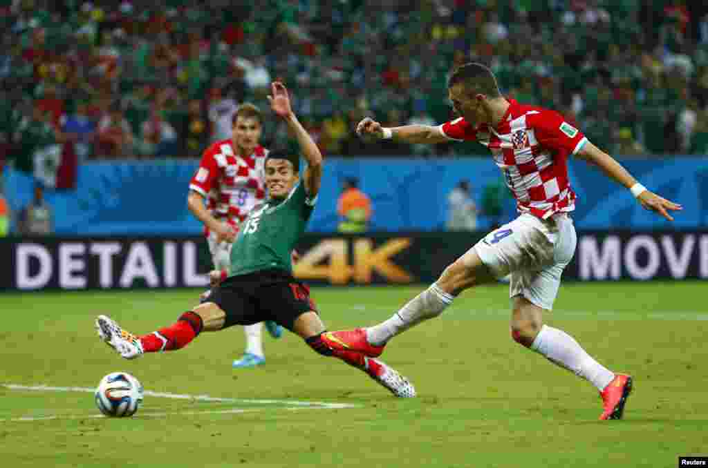 Pemain Kroasia Ivan Perisic, kanan, melewati pemain Meksiko Hector Moreno dalam pertandingan di Pernambuco Arena di Recife, 23 Juni 2014.