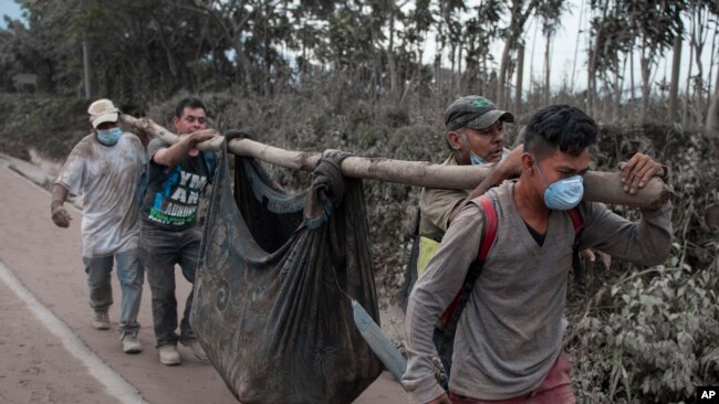 Residentes llevan un cuerpo recuperado cerca del VolcÃ¡n de Fuego en Escuintla, Guatemala, el lunes, 4 de junio de 2018.