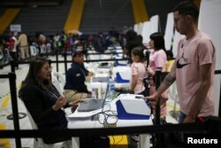 Un migrante venezolano escanea sus huellas dactilares durante un día de entregas de Permiso de Protección Temporal (PPT) organizado por Migración Colombia en el Palacio de los Deportes en Bogotá, Colombia, el 1 de septiembre de 2023. REUTERS/Luisa González