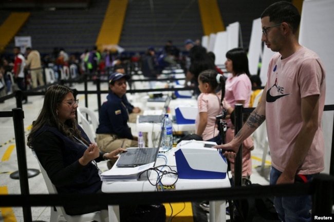 Un migrante venezolano escanea sus huellas dactilares durante un día de entregas de Permiso de Protección Temporal (PPT) organizado por Migración Colombia en el Palacio de los Deportes en Bogotá, Colombia, el 1 de septiembre de 2023. REUTERS/Luisa González