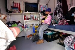 John Golka hugs his dog Smalls inside a tiny home, February 25, 2021, in the Chandler Street Village. (AP Photo/Marcio Jose Sanchez)