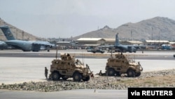 FILE - US Army soldiers patrol Hamid Karzai International Airport in Kabul, Afghanistan, Aug. 17, 2021. The fall of the Western-backed Afghan government gave the country's new Taliban rulers access to more than $7 billion worth of US defense equipment, SIGAR confirmed. (US Air Force handout via Reuters)