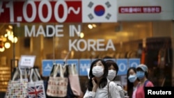 Tourists wear masks to prevent contracting Middle East Respiratory Syndrome (MERS) as they walk around a shopping district in central Seoul, South Korea, June 11, 2015. (AP PHOTO)