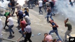 Palestinians run from tear gas thrown by Israeli police officers outside Jerusalem's Old City, July 21, 2017. Israel police severely restricted Muslim access to a contested shrine in Jerusalem's Old City Friday to prevent protests over the installation o