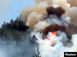 In this photo provided by Inciweb, flames and smoke billow skyward as a wildfire burns near Durango, Colo., June 7, 2018.