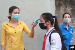 A student is scanned for temperature before entering Dinh Cong secondary school in Hanoi, Vietnam Monday, May 4, 2020.