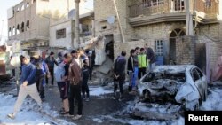 Residents gather at the site of a car bomb attack in the Hurriya district in Baghdad, January 10, 2013.